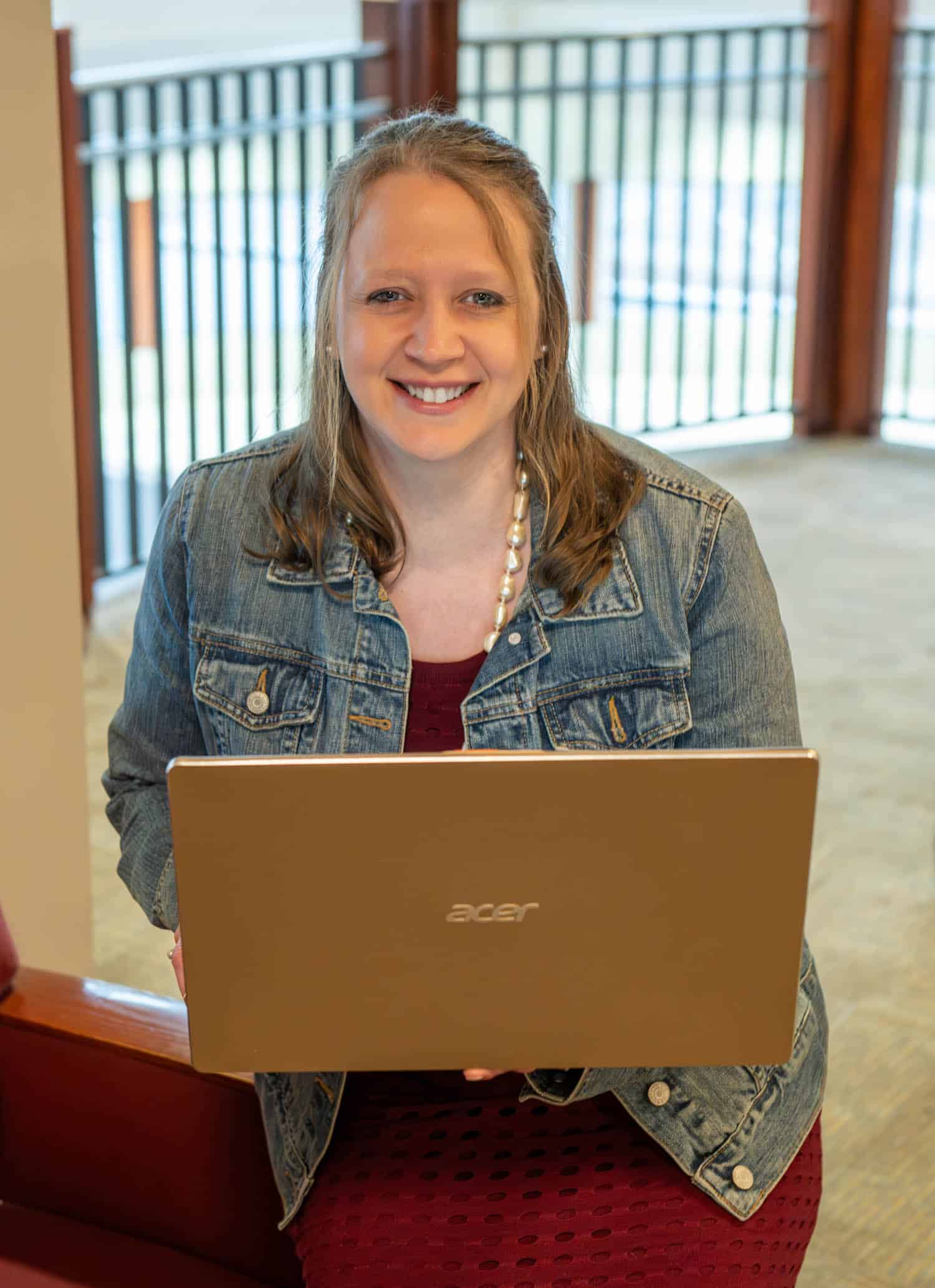 lori kendall siting and holding a latptop
