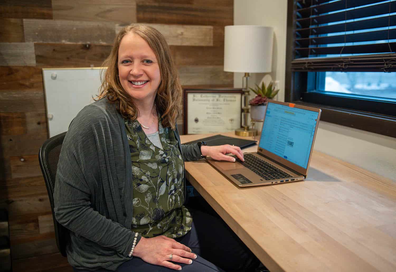 lori kendall sitting at a desk looking at a camera