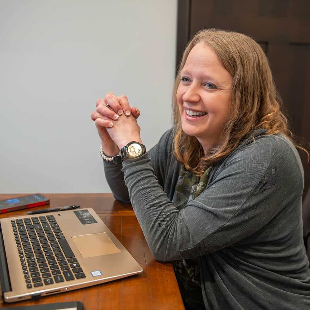 lori kendall at a desk with a laptop